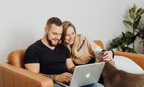 Couple sitting on sofa with laptop